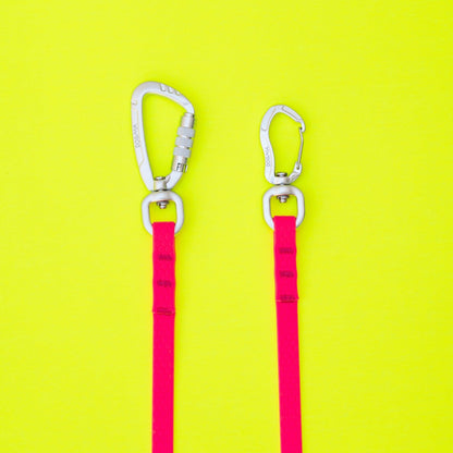 Two pink carabiners with clips on a yellow background