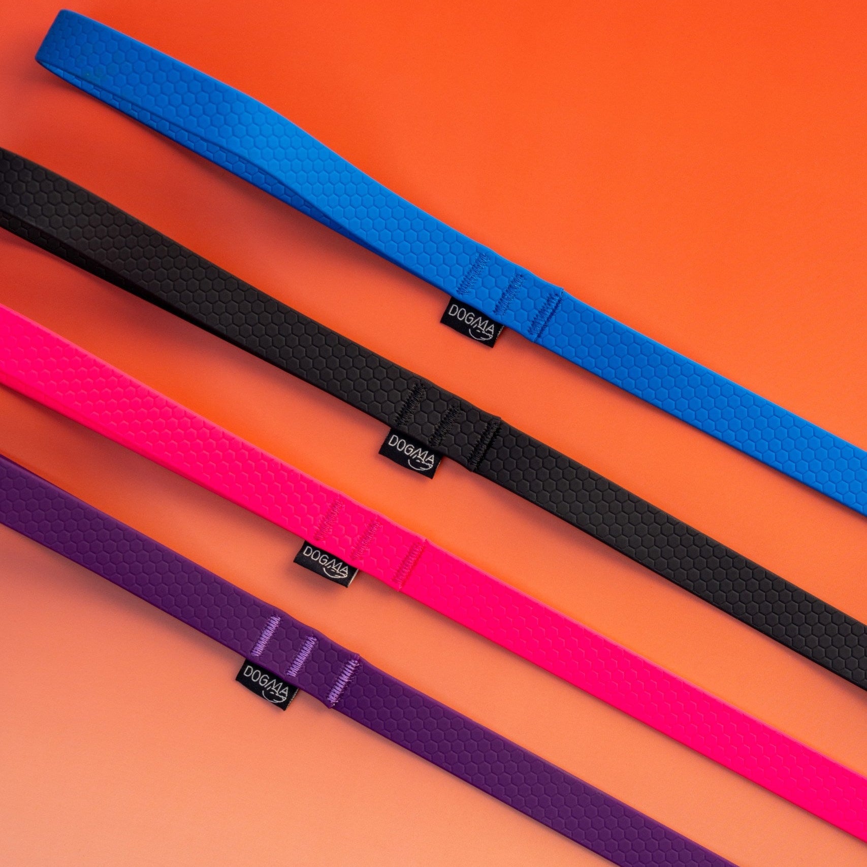 Four colorful belts (blue, black, pink, purple) on an orange background